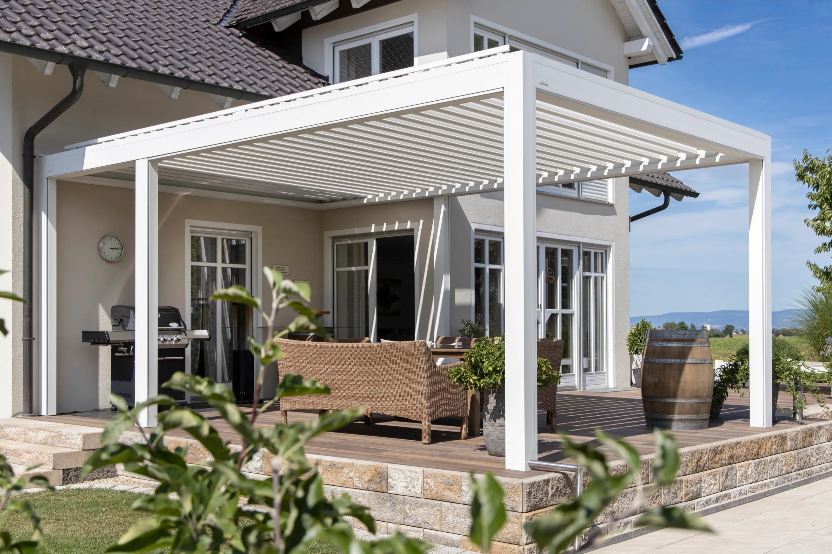Weißes Lamellendach als Erweiterung eines Wohnhauses mit Terrasse