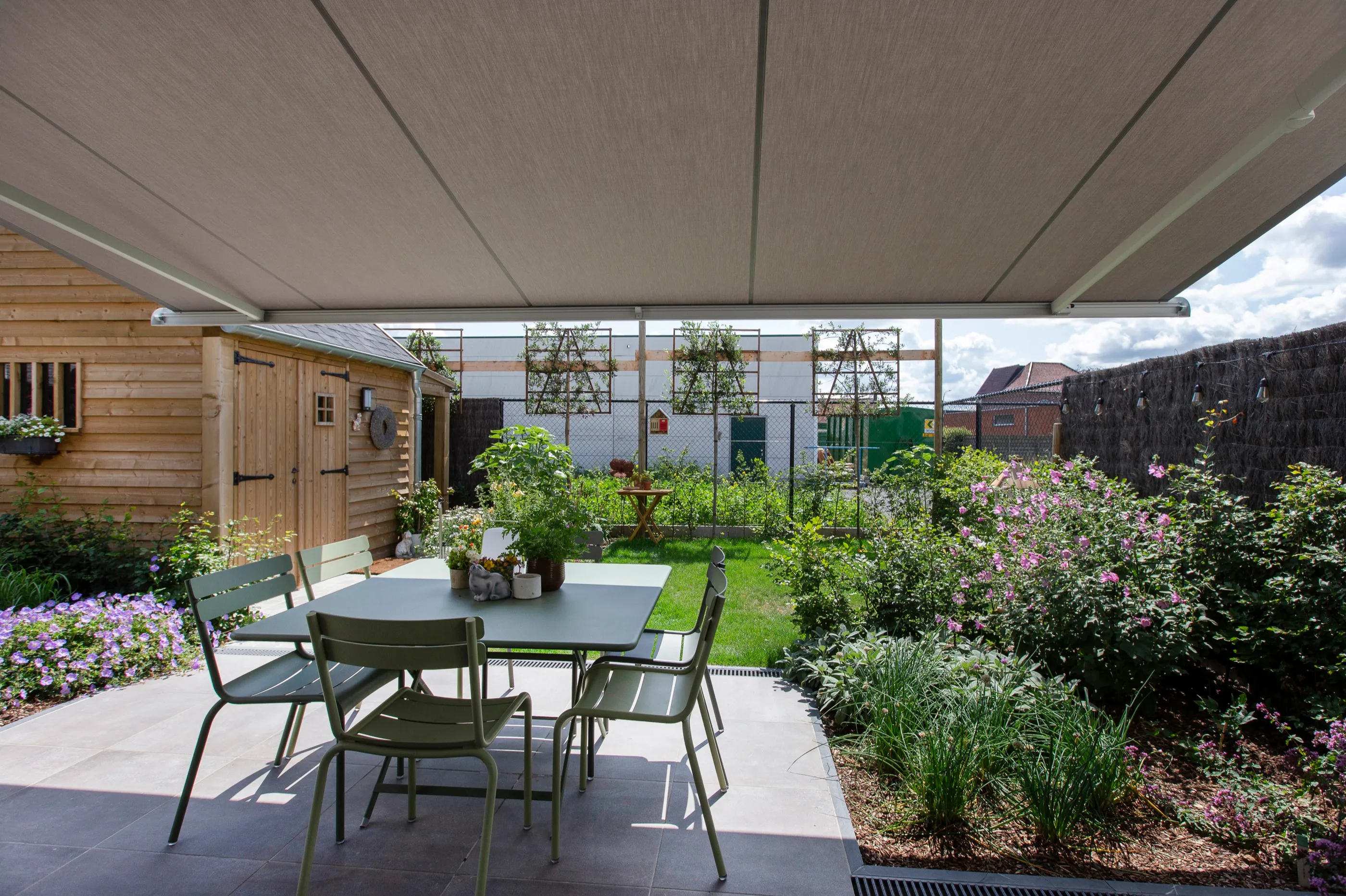 Blick vom beschatteten Terrassentisch in den Garten