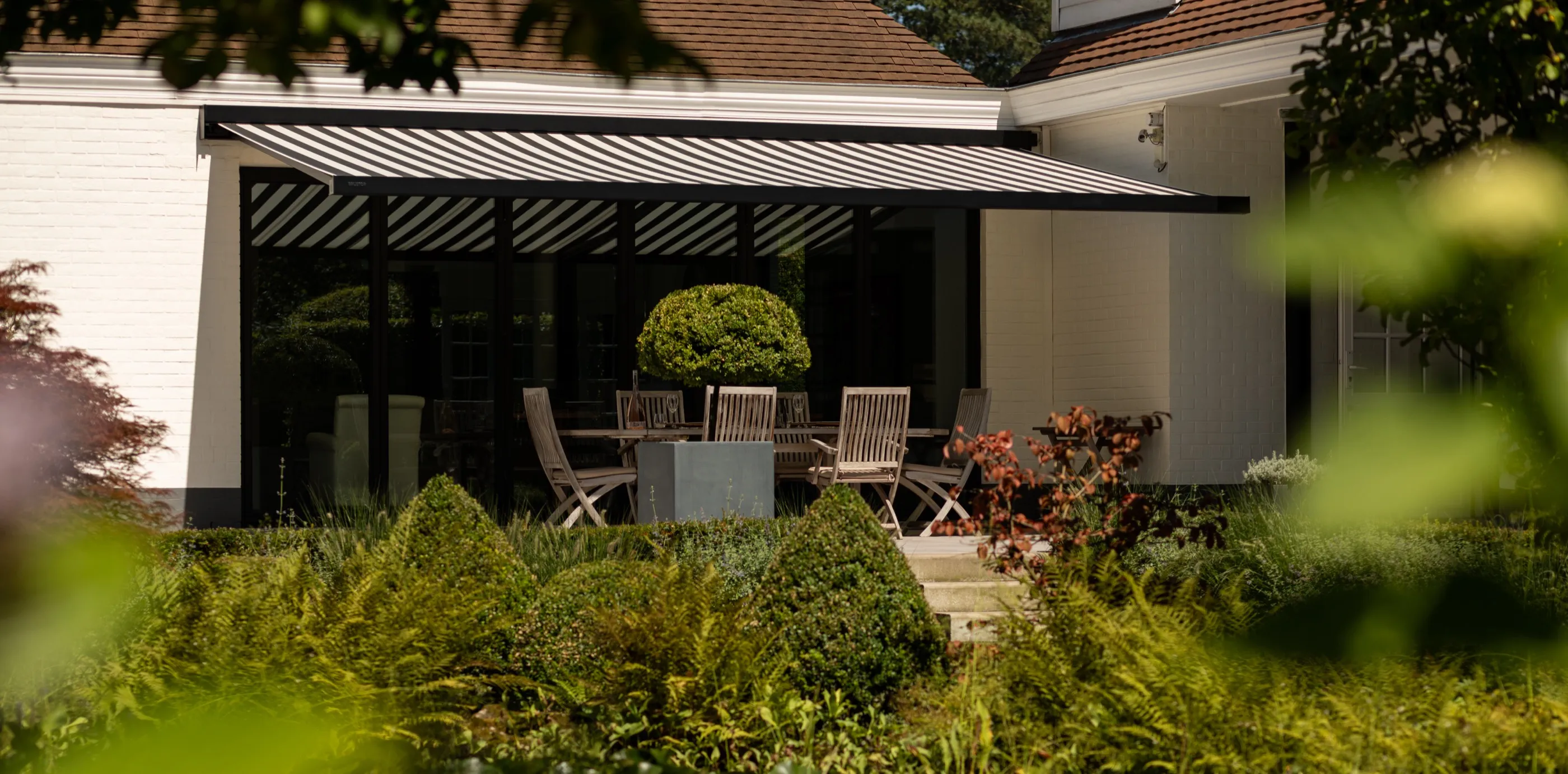 Ausgefahrene Markise über einer Terrasse mit Sitzmöbeln